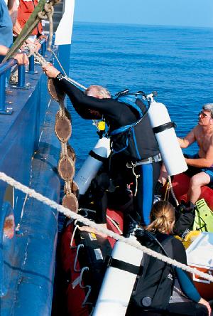 Larry Madin Stepping Down Into Achilles Inflatable Dive Boat. Kelly Rakow at the stern.
