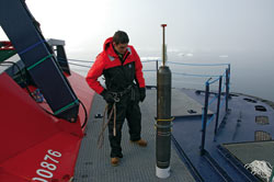 WHOI scientist Luc Rainville, on the Swedish icebreaker Oden in August, prepares to test an experimental float designed for under-ice operations in the Arctic.