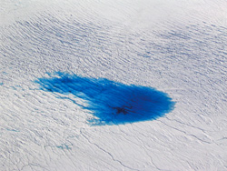 Supraglacial lakes, several kilometers long, form in summer from melted ice atop the Greenland Ice Sheet.