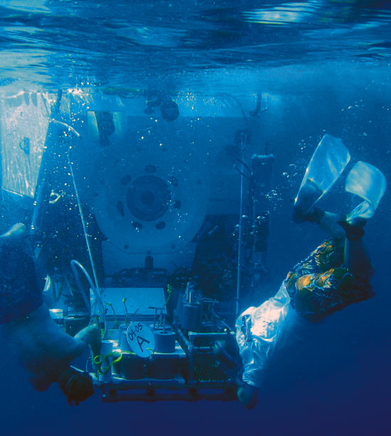 Carl Wood (left), R/V Atlantis steward, and Ken Feldman, a shipboard technician, are also certified swimmers who help launch and recover the WHOI-operated deep-diving submersible Alvin. In the famed submersible?s 41-year history, only 35 people?with an underwater brand of the ?right stuff??have become Alvin pilots.