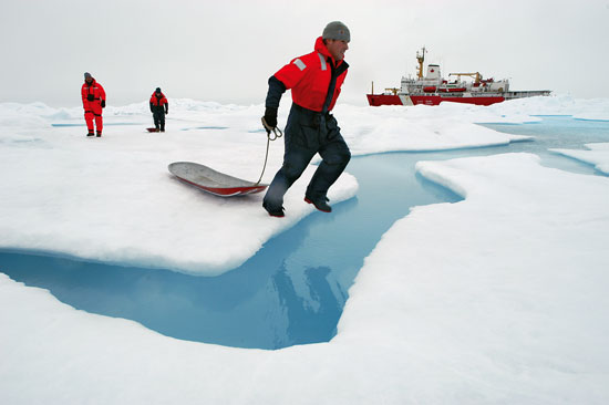 WHOI engineer Kris Newhall jumps across a melt pond.