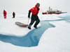 WHOI engineer Kris Newhall jumps across a melt pond.