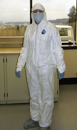 WHOI scientist Rhian Waller wears a protective suit, mask, and gloves