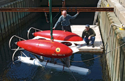 Before ABE's first deployment, ABE's inventors, Al Bradley (left) and Dana Yoerger tested the autonomous underwater vehicle in the test well at the WHOI dock in Woods Hole.