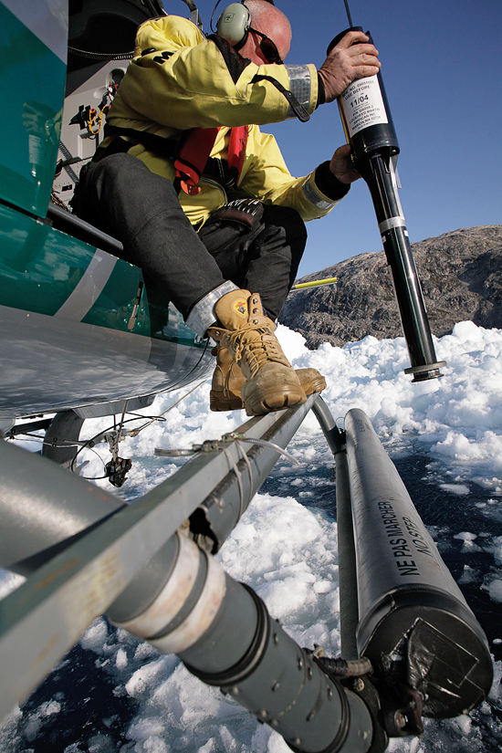 WHOI mooring engineer Jim Ryder aims an XBT at a patch of open water in Kangerdlugssuaq Fjord