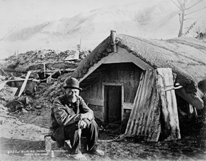 Maori man in front of buried house after eruption of Mt. Tarawera