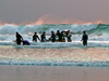 Researchers carry an instrument tower into the surf.