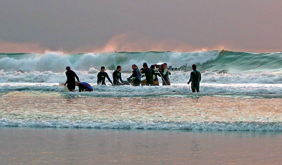 Researchers carry an instrument tower into the surf.