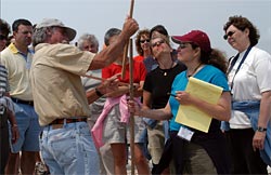 Researcher Jim O'Connell shows teachers, participating in a workshop, how to measure the shoreline depth. 