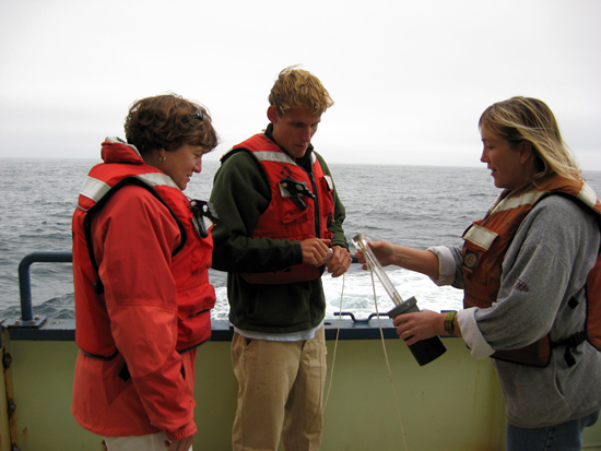 Amy, graduate student Dave Sutherland, and unidentifiied crew member collect a water sample.