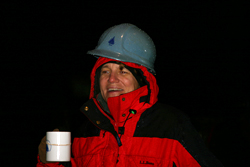 On the rainy deck of the <em>Knorr</em>, Amy Bower, drinking hot chocolate to keep warm, watches, as the mooring slowly unspools.