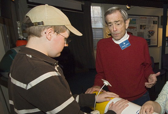 WHOI volunteer Sheldon Holzer showing a student a REMUS vehicle at the WHOI exhibit center.