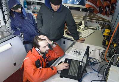 Andrey is on the phone with Greg Packard, REMUS expert from the WHOI Applied Ocean Physics and Engineering Department, getting some technical advice at sea