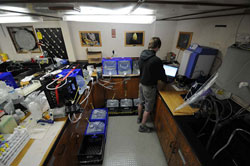 The lab space on R/V KOK has been configured to do many things and to remain safe in heavy weather. This corner is devoted to both processing water samples, which are lashed to the counter and floor, for cesium analysis and to Jarvis CaffreyÂs station radiation monitoring station.