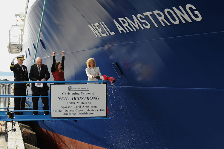 Carol Armstrong, ship's sponsor for the Auxiliary General Oceanographic Research (AGOR) research vessel (R/V) Neil Armstrong (AGOR 27), breaks a bottle across teh bow during a christening ceremony at Dakota Creek Industries, Inc., shipyard in Anacortes, WA