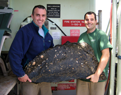 Chris Reddy (left) of WHOI and Chief Scientist Dave Valentine of UCSB hold a large chunk of undersea asphalt collected with one of the robotic arms of the DSV Alvin. The sample was surprising light in weight compared to rock.