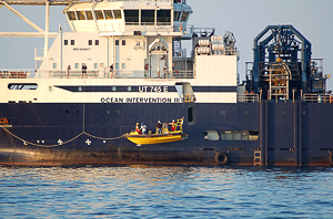 fast boat with passengers being hoisted onto the Ocean Intervention III