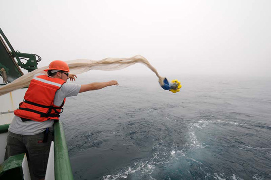 Justin Smith from the University of Hawaiis Ocean Technology Group heaves the sample collection container for the Methot net off the stern of the R/V KOK.