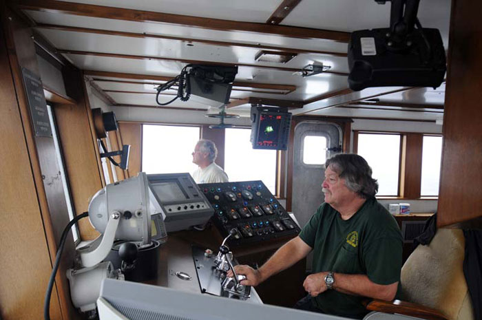 Capt. Clary Gutzeit (right) and Able-Bodied Seaman George Longshore keep the 8-to-noon watch in the pilothouse as the weather worsens.