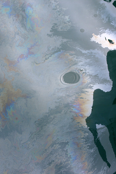 A fresh oil slick from the Deepwater Horizon spill, during June 2010.  Note that one drop of detergent was added to the oil slick, forming the cleared circle.