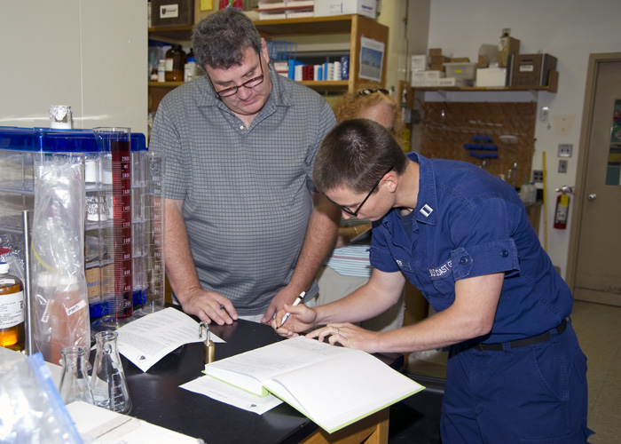 Bob Nelson and Coast Guard officer sign chain-of-custody papers for the sample from Deepwater Horizon
