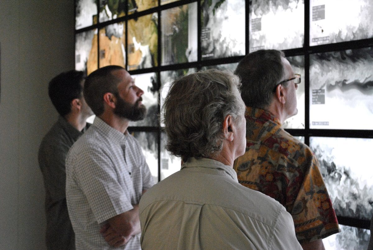 Physical oceanographers from WHOI, NASA, and Univ. of North Carolina at the NASA Ames Hyperwall visualization center examine the evolution of sea surface salinity in a computer simulation.