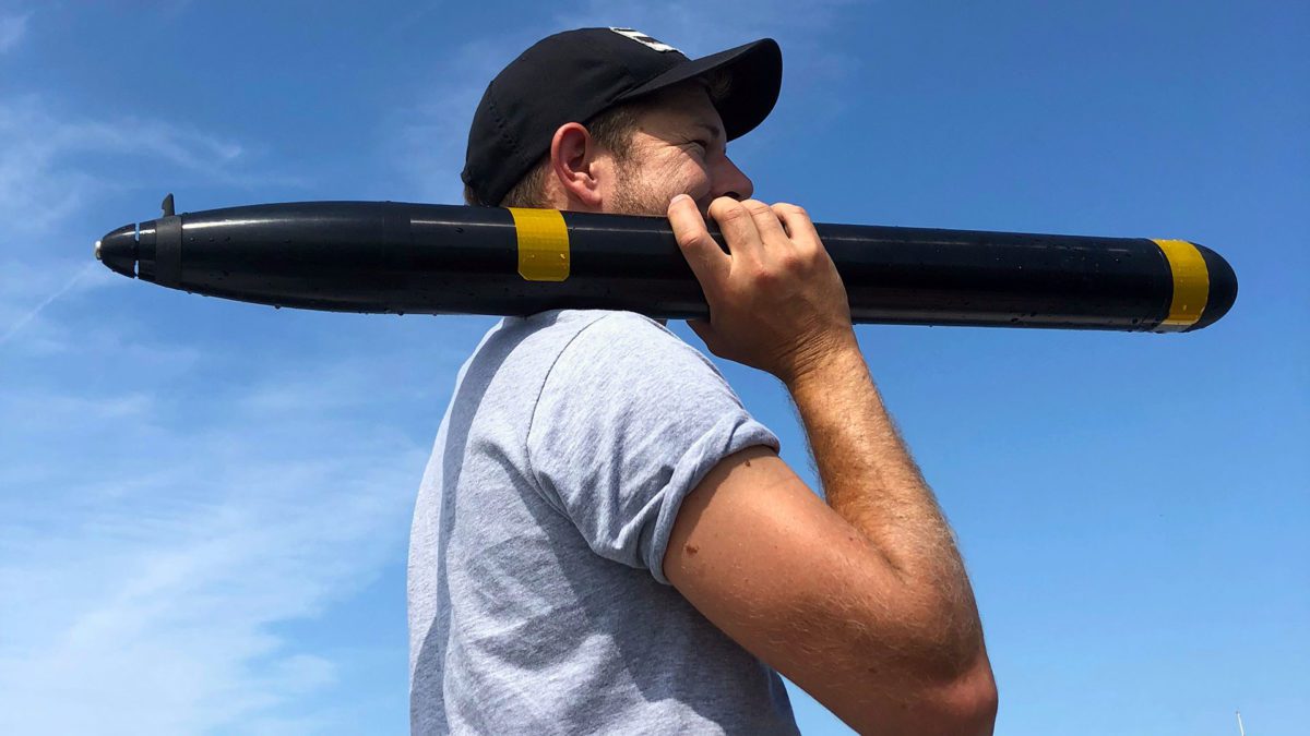 Robin Littlefield carries an early "single-blade" prototype during testing of Asymmetric Propulsion in Great Harbor.