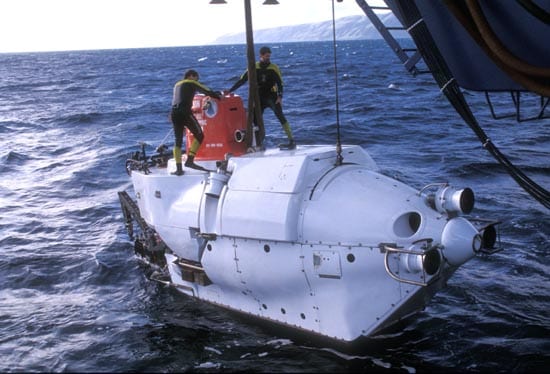 Support swimmers stand by to remove the lift lines as Alvin goes into the water on a cold water launch. (Woods Hole Oceanographic Institution)