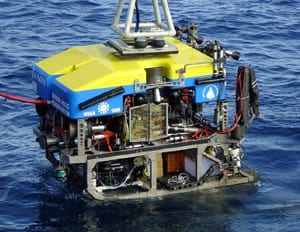 A traction winch lowers Jason into the water during sea trials in 2002. The red tether at left will remain attached during the entire dive, supplying power and relaying data between Jason and the ship. (photo courtesy Dan Fornari, WHOI)