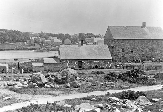 The Candle House, at right in the photo from about 1890, is all that remains of mid-nineteenth-century whaling in Woods Hole. The smaller building at center housed the try works, where whale oil was rendered. Today the Candle House is used by the Marine Biological Laboratory (MBL) for offices. (Photo by Baldwin Coolidge, Marine Biological Laboratory Archives)