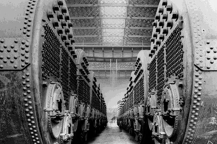 A man standing in the Harland Wolff boiler shop is dwarfed by a row of 17-foot high boilers.