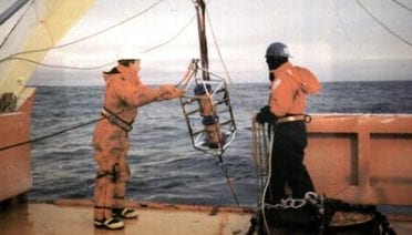 Two ADCPs are often lowered together, one facing the surface and the other facing the bottom, to double the length of the current profile. The metal cage around the ADCPs that Senior Engineering Assistant Scott Worrilow of the Woods Hole Oceanographic Institution is helping overboard holds the instruments in place and protects them from accidental bangs against the ship's hull. (Claudia Cenedese)