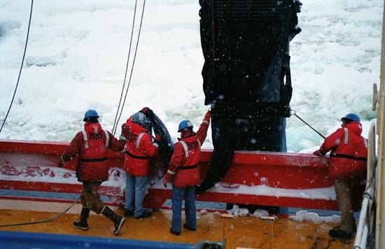 In a snowstorm on a 2002 cruise in the Southern Ocean, workers ready the MOCNESS nets for launching (Woods Hole Oceanographic Institution)