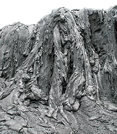Pahoehoe flows cascading over a small scarp near the ocean entry of the Pu’u Oo flow, Kilauea volcano Hawaii in June, 2001. Scale from top to bottom of scarp is about 4 meters.