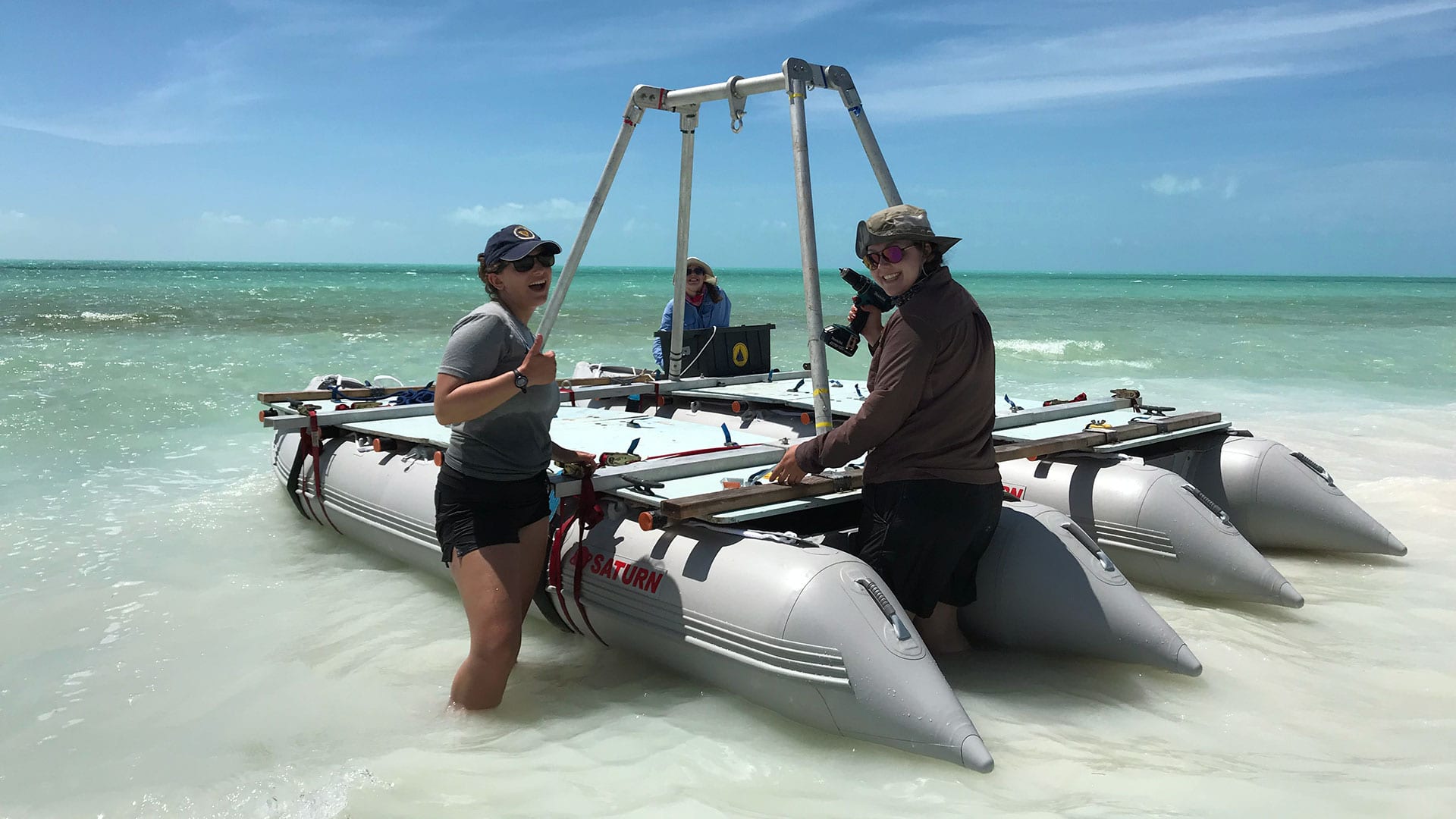 WHOI researchers Lizzy Soranna (front left), Lizzie Wallace (front right), and Nicole D'Entremont head out to conduct hurricane research in an azure-colored marine sinkhole—formally known as a blue hole—off Caicos Island in the Caribbean. They collected sediment samples from the bottom of the hole to learn more about the characteristics of Hurricane Irma, a Category 5 storm that passed over the area in early September of 2017. (Photo by Rose Palermo, Woods Hole Oceanographic Institution).