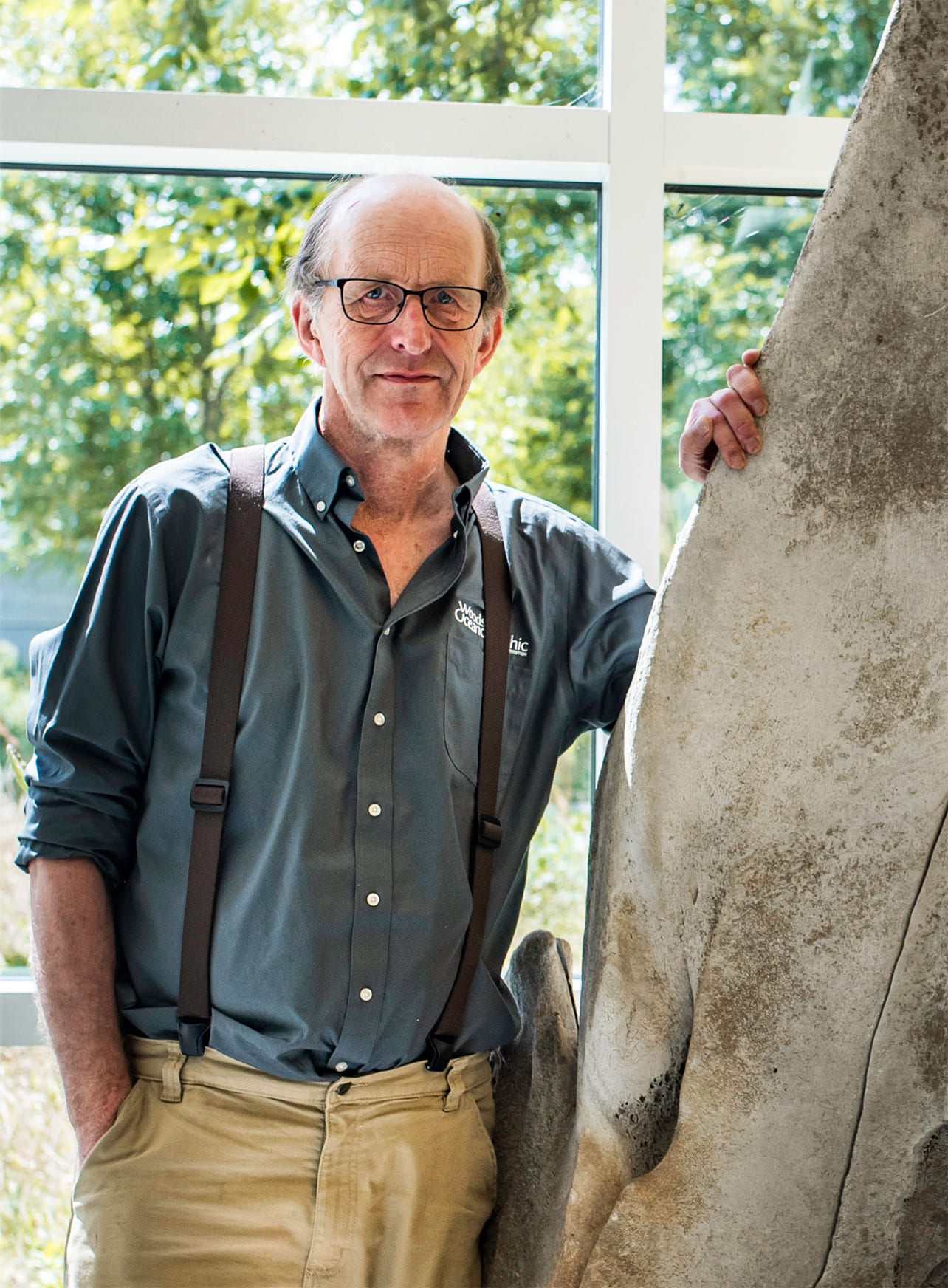 Michael Moore stands next to the skull of a sperm whale in the Marine Research Facility at Woods Hole Oceanographic Institution. (Photo by Daniel Hentz, Woods Hole Oceanographic Institution)