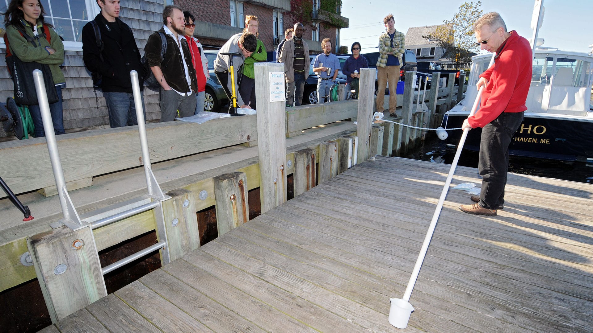 WHOI scientist Bernhard Peucker-Ehrenbrink demonstrates how to sample river water for participants in the Global Rivers Observatory project. The project addresses the flow of water, sediments, and nutrients into the oceans from major river basins worldwide. (Photo by Jayne Doucette, Woods Hole Oceanographic Institution)