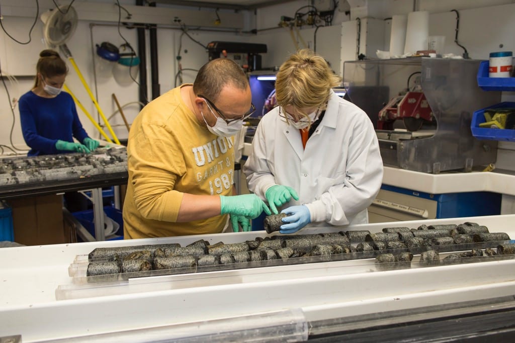 Researchers Benoit Ildefonse (left) of University of Montpellier and Virginia Edgcomb of WHOI select a sample for microbiology during the expedition at Atlantis Bank, Indian Ocean. (Photo by  Jason Sylvan, TAMU)