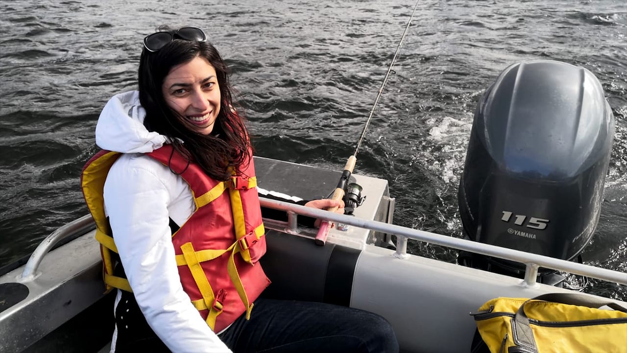 Melina Kourantidou, a post doctorate fellow and fisheries economist at WHOI’s Marine Policy Center, fishes for Arctic Char, one of the most prevalent and traditionally consumed fish species in the Nunatsiavut region. (Photo by Rachel Cadman, Dalhousie University)