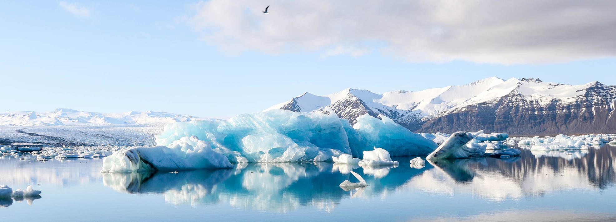 An iceberg reflects in the still waters of Jökulsárlón, Iceland (Photo courtesy of Jeremy Bishop via Unsplash)