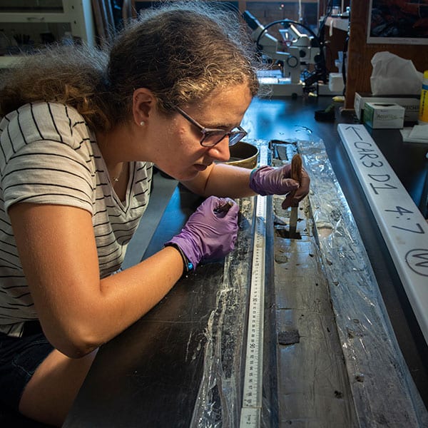 WHOI Summer Student Fellow Rachel Gold (Brown University) examines a sediment core from Lake Carmi, Vermont. The sediments provide evidence of an inland seaformerly known as the Champlain Sea that flooded the region at the end of the last Ice Age when the Saint Lawrence Seaway opened as glaciers retreated. Golds research project, which was conducted under the direction of WHOI geologist Jeff Donnelly, involved determining the timing of this event to better understand how meltwater entering the North Atlantic through this new channel affected ocean circulation and climate. (Photo by Tom Kleindinst © Woods Hole Oceanographic Institution)