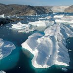 A large iceberg has broken away from the Helheim Glacier and floats among slabs of pack ice in Sermilik Fjord along the southeastern coast of Greenland. The glacier, about 3 miles wide at its mouth, has been shrinking rapidly in recent years. WHOI researchers are investigating whether changes in the fjords are contributing to the loss of ice. (Photo by Nick Cobbing © Greenpeace International)