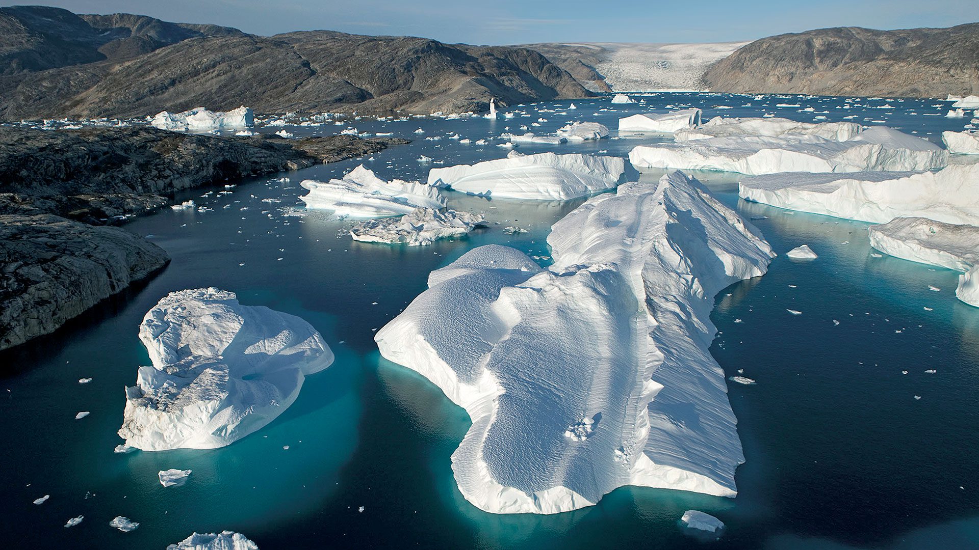 A large iceberg has broken away from the Helheim Glacier and floats among slabs of pack ice in Sermilik Fjord along the southeastern coast of Greenland. The glacier, about 3 miles wide at its mouth, has been shrinking rapidly in recent years. WHOI researchers are investigating whether changes in the fjords are contributing to the loss of ice. (Photo by Nick Cobbing © Greenpeace International)