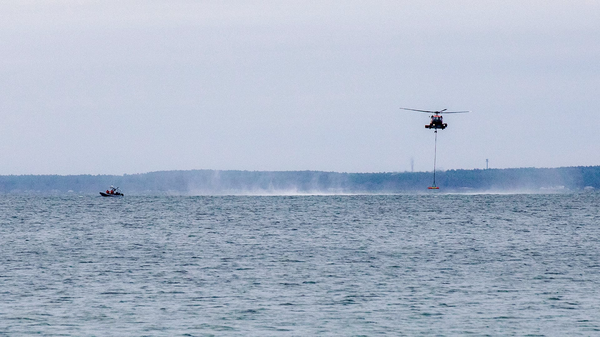 A USCG Jayhawk helicopter releases LRAUV near the Scibotics Team aboard a Zodiac in Buzzards Bay, where the team can inspect the vehicle's systems underwater. (Jayne Doucette, © Woods Hole Oceanographic Institution)