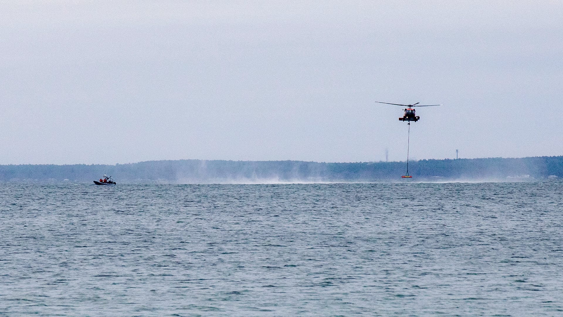 A USCG Jayhawk helicopter releases LRAUV near the Scibotics Team aboard a Zodiac in Buzzards Bay, where the team can inspect the vehicle's systems underwater. (Jayne Doucette, © Woods Hole Oceanographic Institution)