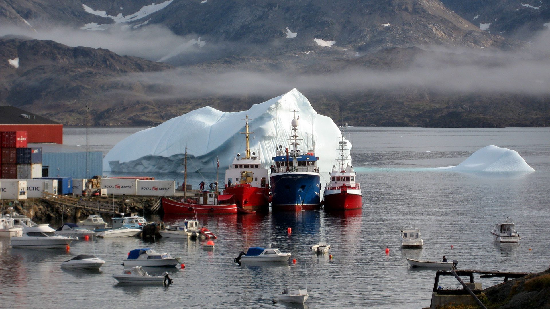 Icebergs drift into the port of Tasiilaq in Greenland, where WHOI scientists and colleagues from the University of Maine were based this summer while measuring ocean temperatures in nearby Sermilik Fjord. The goal was to investigate if the recent acceleration of Greenland's ice sheet is due to ocean warming ocean, said WHOI researcher Fiamma Straneo. Scientists collected measurements using a small boat, which they could navigate easily through the maze of icebergs and sea-ice bobbing in the fjord. The larger vessels in the background are (from left) the local ferry, a Faeroese fishing boat, and a visiting police boat from Nuuk. (Photo by Fiamma Straneo © Woods Hole Oceanographic Institution)
