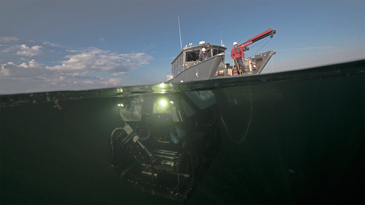 An expedition team deploys ROV <em>Yogi</em> to explore hydrothermal explosion craters at the bottom of Yellowstone Lake (Chris Linder, © Woods Hole Oceanographic Institution)