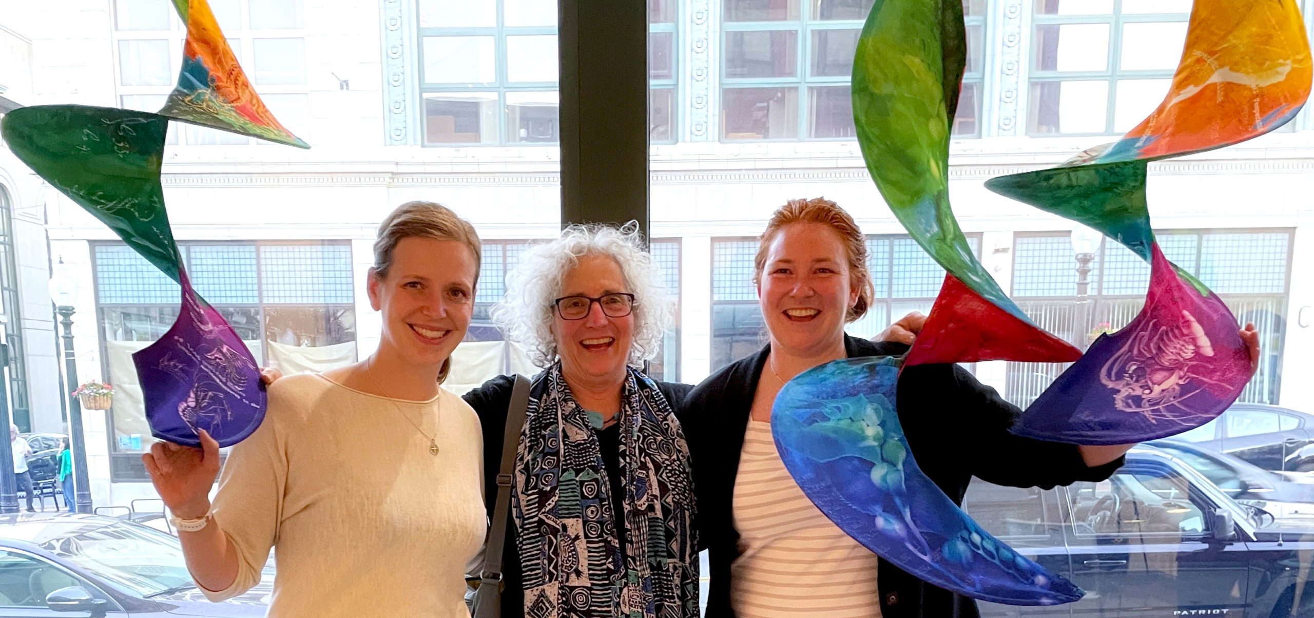 From left to right, WHOI post-doc Svenja Ryan, artist Deb Ehrens, and physical oceanographer Caroline Ummenhofer, with Ehrens' sculpture "Marine Heatwaves" on display at South Coast Design in June 2021. (Photo by Adrian Burke)