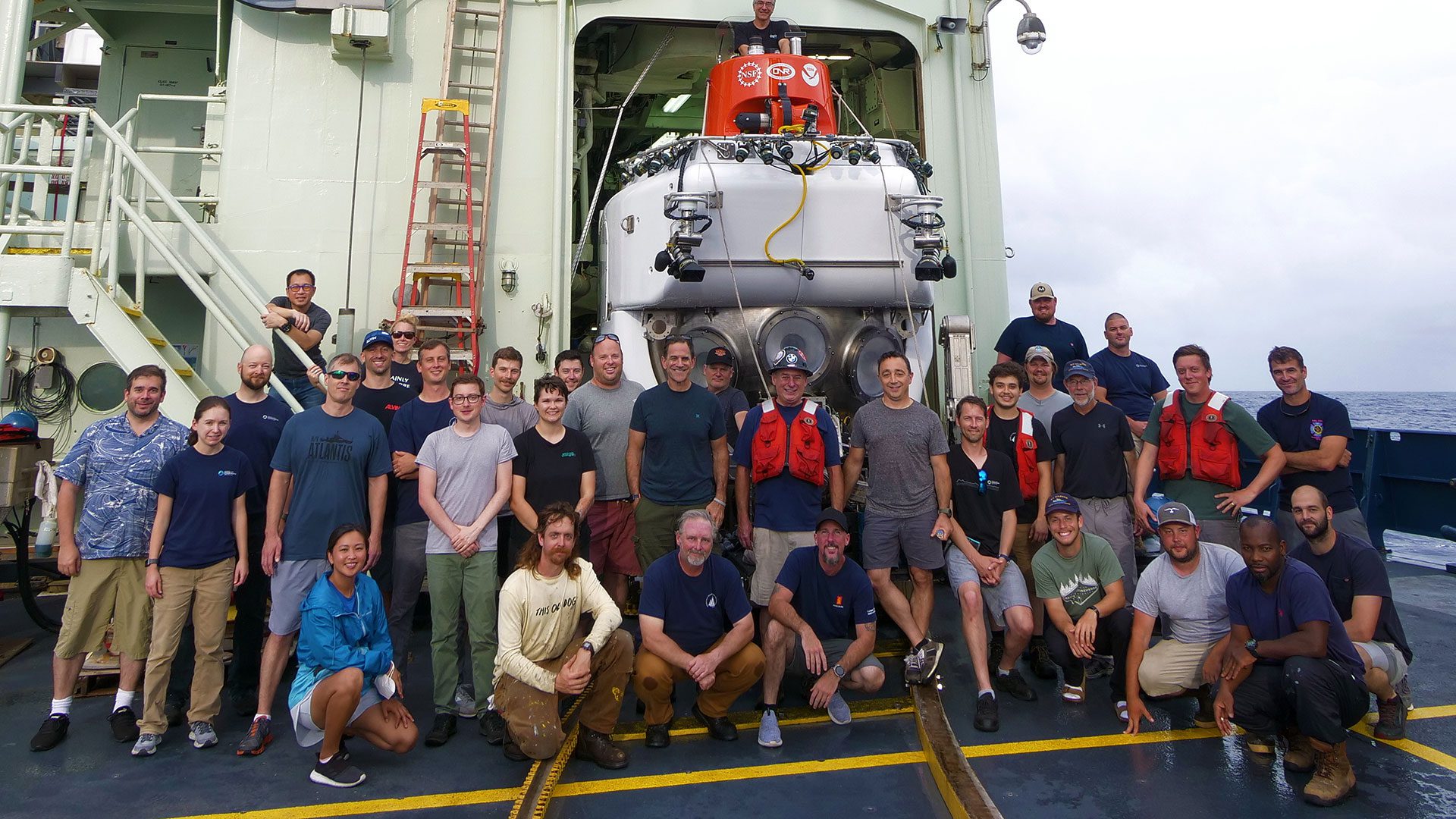 July 21, 2022: the <em>Alvin</em> team on the deck of the R/V <em>Atlantis</em> after <em>Alvin</em>'s historic dive. Earlier today, the submersible reached 6,453 meters, its deepest dive ever. (Image by Ken Kostel © Woods Hole Oceanographic Institution)