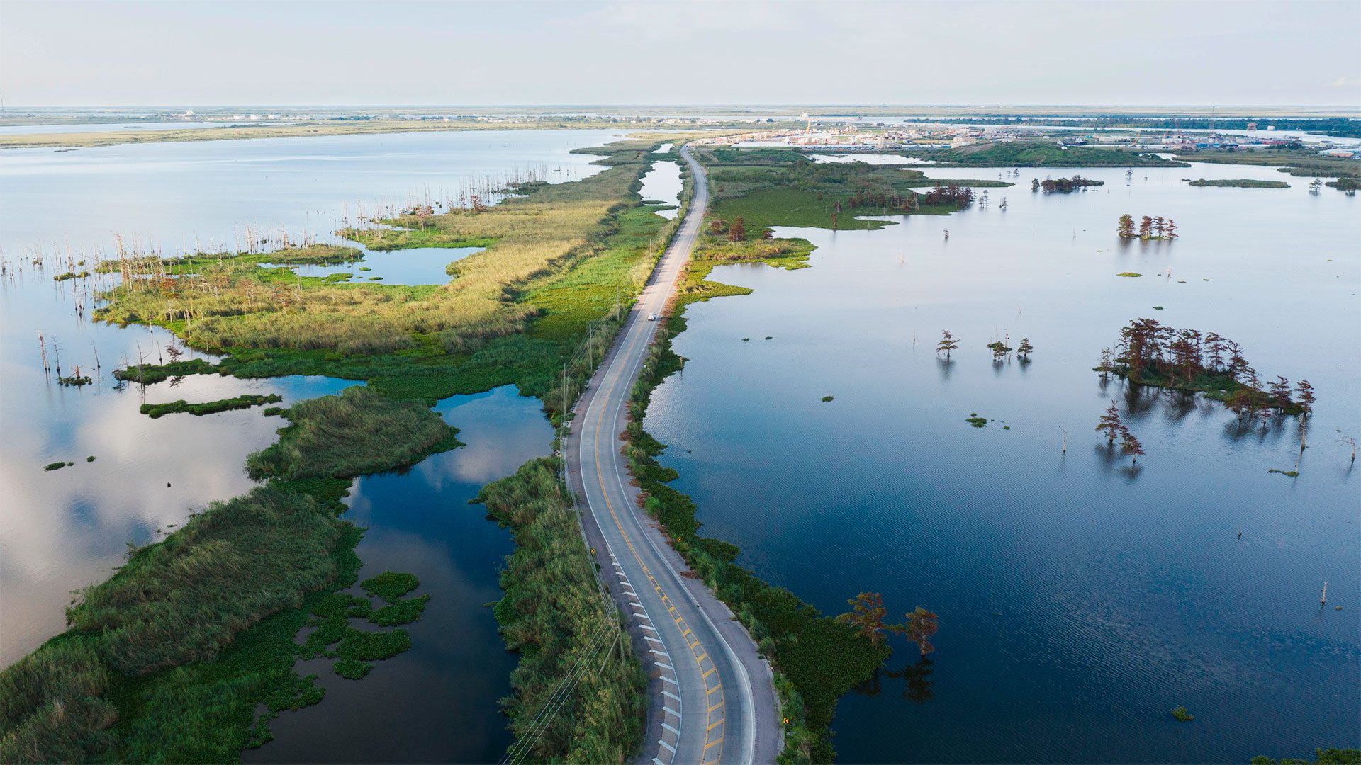 In Louisiana, a car meanders through a low-lying road flanked by swamps in the Mississippi River Delta. (Photo by Odysseas Chloridis, © Alamy Stock Photos)